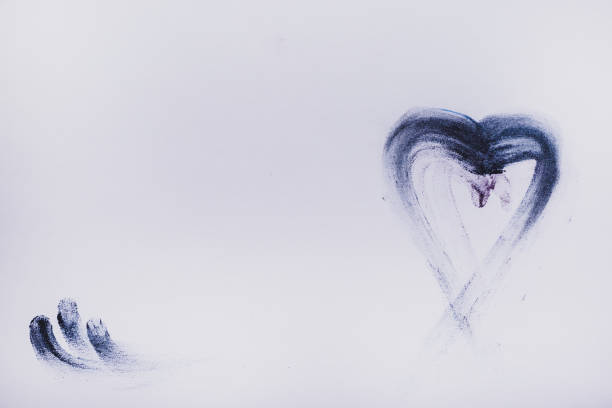 A red heart with beams drawn by a lipstick on a white paper. Love concept.