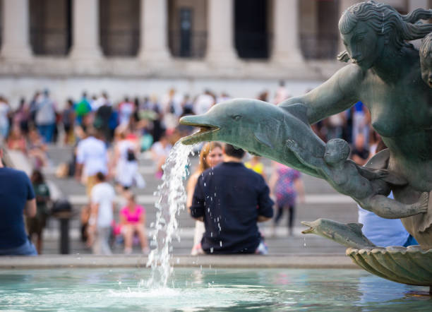 Fountain on the Trafalgar square and blurred people at the background. London