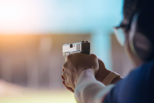 law enforcement aim pistol by two hand in academy shooting range law enforcement aim pistol by two hand in academy shooting range in flare and vintage color shooting stock pictures, royalty-free photos & images