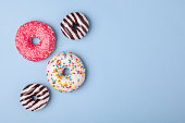 four different donuts isolated on blue background