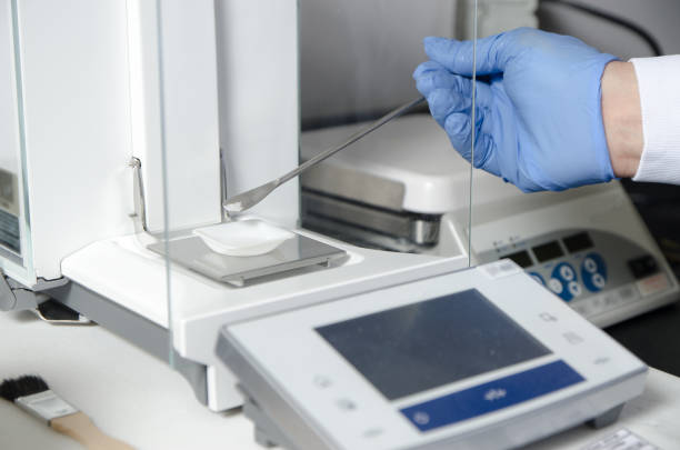 primo passo su operaio di laboratorio che pesa prodotto chimico o farmaco su bilancia elettronica - bacteriologist foto e immagini stock