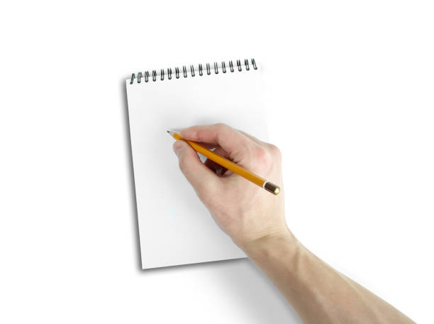 istock Right hand writing on notebook with white background. Top view of work desk. Isolated on white background 666187868