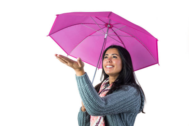 Woman checking the weather from under her umbrella against a white background