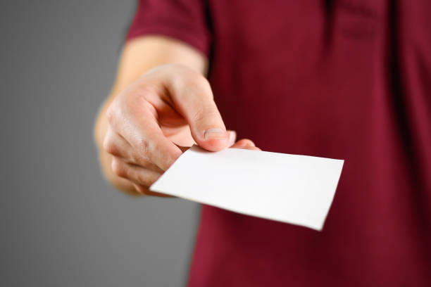 istock Man showing blank white square flyer brochure booklet. Leaflet presentation. Pamphlet hold hands. Man show clear offset paper. Sheet template. Booklet design sheet display read first person 666190278