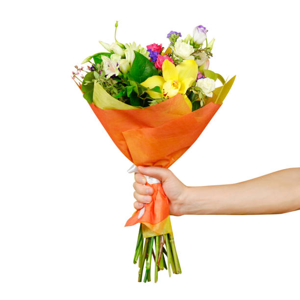Hand holding a beautiful bouquet of different flowers. Isolated on a white background Hand holding a beautiful bouquet of different flowers. Isolated on a white background. bunch of flowers stock pictures, royalty-free photos & images