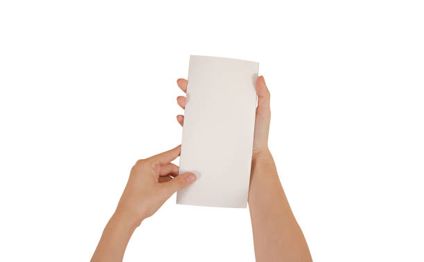 istock Hands holding blank white brochure booklet in the hand. Leaflet presentation. Pamphlet hand man. Show offset paper. Sheet template. Book in hands. Booklet folding design. Isolated on white background 666190400