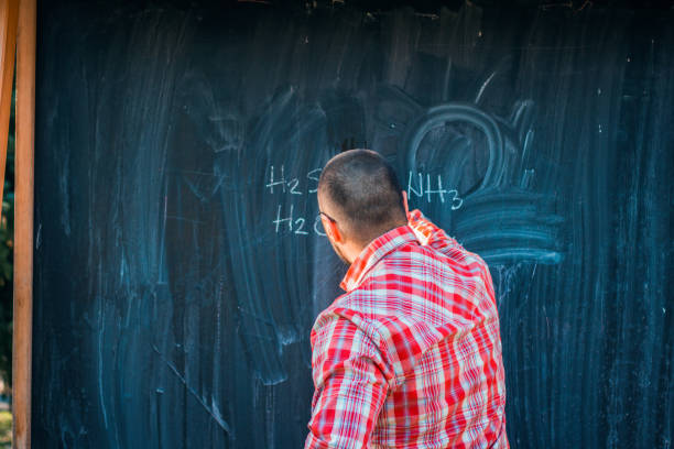 istock Man standing in front of blackboard with chemical formula 666190568