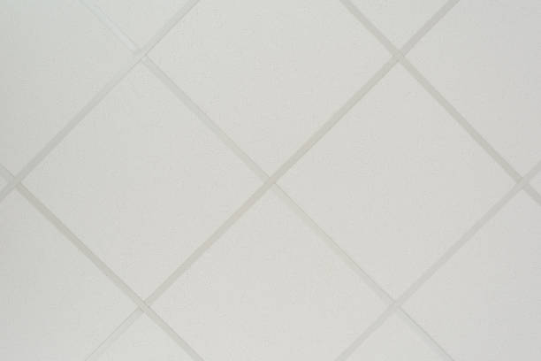 The texture of a false ceiling consisting of square plates and a directing profile of the diagonal arrangement, an abstract white background stock photo