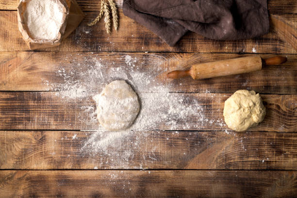 istock Fresh dough sprinkled with flour on a wooden table 666208396