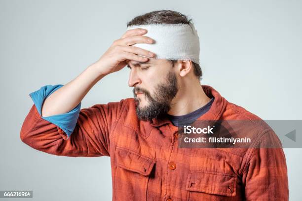 Portrait Of Man With Bandages Wrapped Around His Head Isolated On Gray Background Stock Photo - Download Image Now