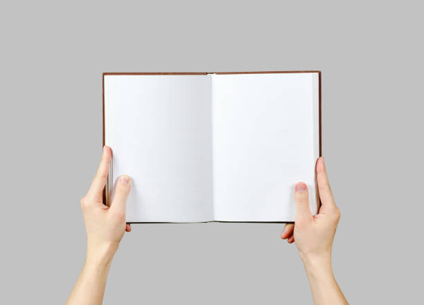 istock Overhead view of hands holding a blank book ready with copy space ready for text. Isolated on grey background. With clipping path 666220252