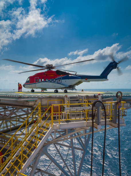 elicottero atterrato su piattaforma di perforazione offshore - oil rig sea oil storm foto e immagini stock