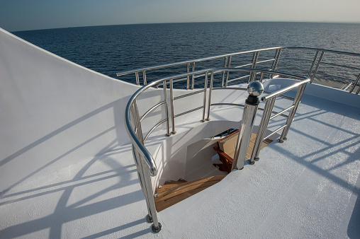 Wooden curved staircase on sundeck area of large luxury motor yacht