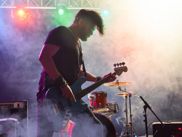 istock Rock band performs on stage. Bassist in the foreground. 666258968