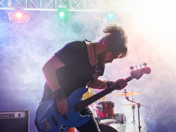 istock Rock band performs on stage. Bassist in the foreground. 666258994