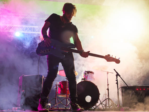 istock Rock band performs on stage. Bassist in the foreground. 666258998