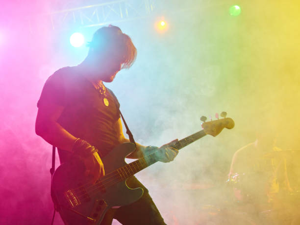 istock Rock band performs on stage. Bassist in the foreground. 666259010