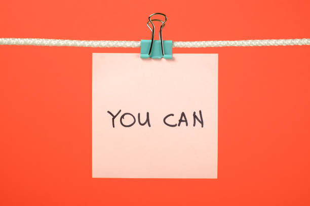 istock Pink paper sheet on the string with text You Can over colorful background 666265668
