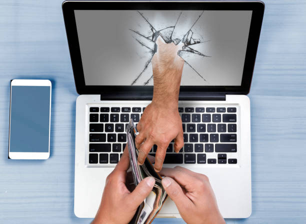 Hand coming out of computer stealing money stock photo