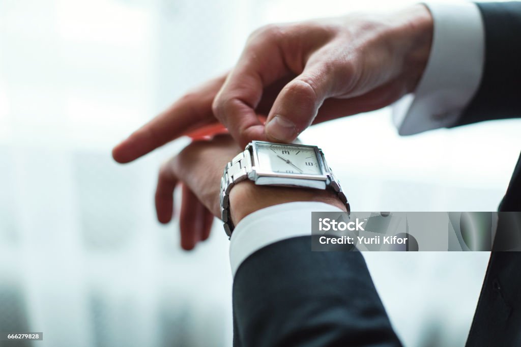 Businessman adjusts clock Businessman adjusts clock. Stylish looks Clock Stock Photo