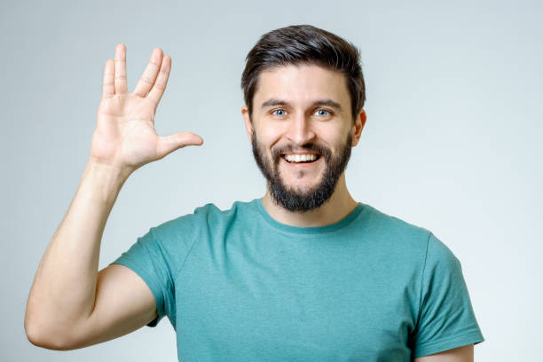 istock Man making Vulcan salute isolated on gray 666284242
