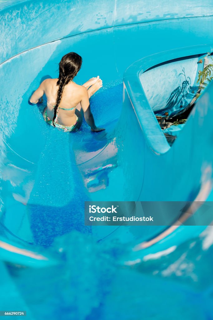 woman going down a water slide young woman going down a water slide. water Park Adult Stock Photo