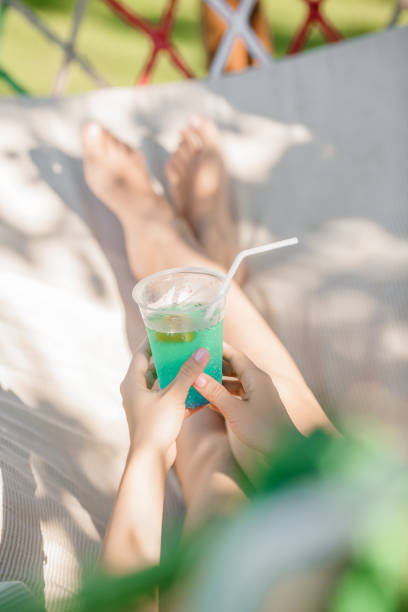 istock woman holding cocktail in the hammock 666293106