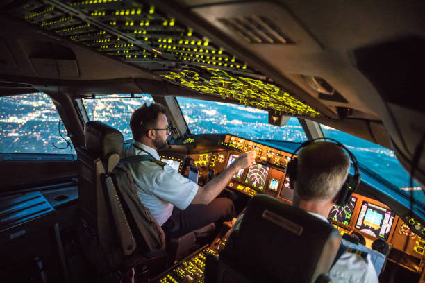 Flightdeck View Two pilots at work during departure of Dallas Fort Worth Airport in United States of America. The view from the flight deck with high workload the beginning night through the wind shield commercial airplane stock pictures, royalty-free photos & images