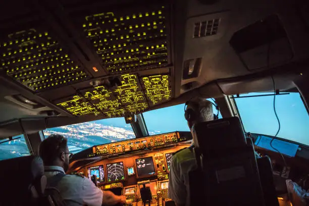 Two pilots at work during departure of Dallas Fort Worth Airport in United States of America. The view from the flight deck piont of view with high workload the beginning night through the wind shield