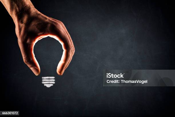 Human Hand Light Bulb On Blackboard New Idea Glowing Stock Photo - Download Image Now
