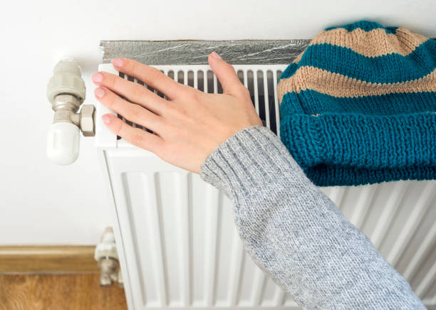 istock Woman's hand adjusting heater Thermostat in winter time 666304620