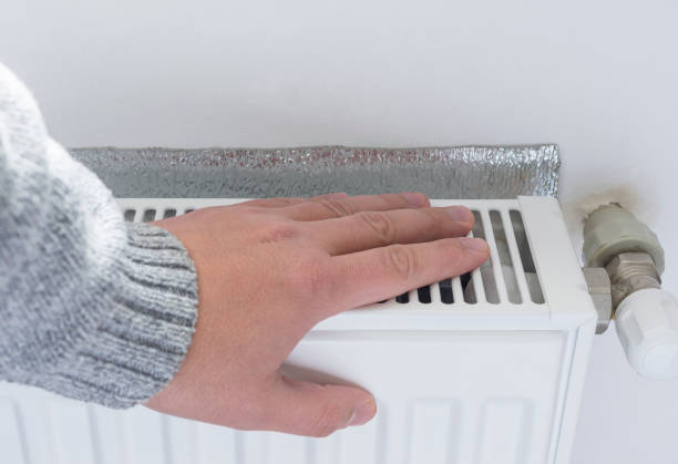 istock Person adjusting thermostat control on a central heating. 666311462