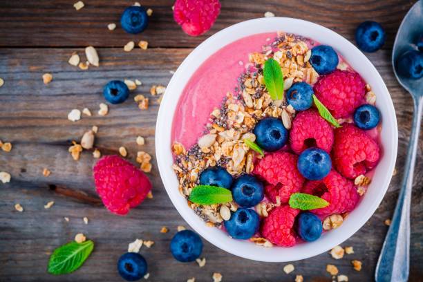 istock Breakfast smoothie bowl  with granola, fresh raspberry, blueberry, chia seeds and mint 666326758