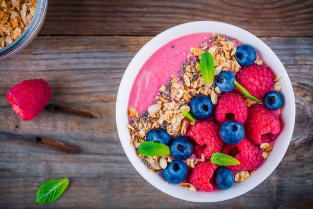 istock Breakfast smoothie bowl  with granola, fresh raspberry, blueberry, chia seeds and mint 666326774