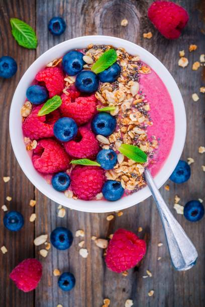 istock Breakfast smoothie bowl  with granola, fresh raspberry, blueberry, chia seeds and mint 666326802