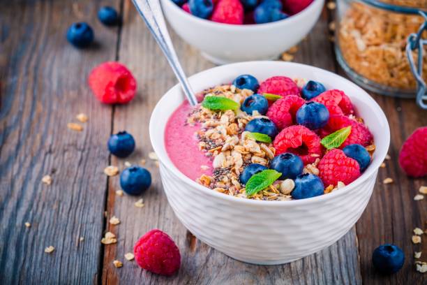 istock Breakfast smoothie bowl  with granola, fresh raspberry, blueberry, chia seeds and mint 666326860