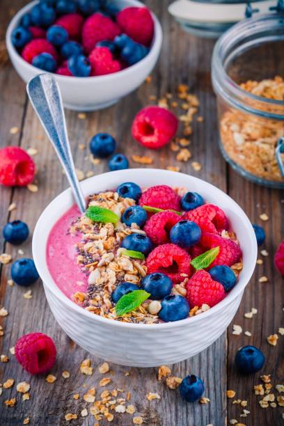 istock Breakfast smoothie bowl  with granola, fresh raspberry, blueberry, chia seeds and mint 666326914