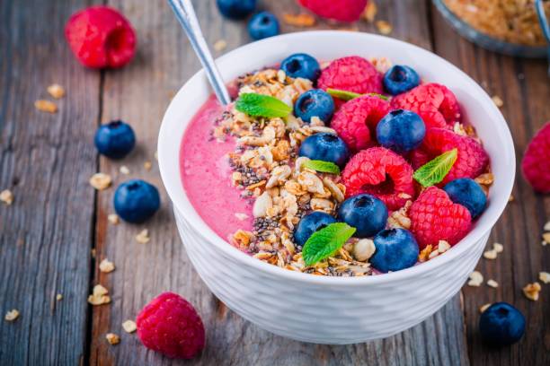 istock Breakfast smoothie bowl  with granola, fresh raspberry, blueberry, chia seeds and mint 666327026