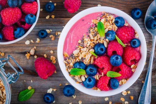 istock Breakfast smoothie bowl  with granola, fresh raspberry, blueberry, chia seeds and mint 666327840