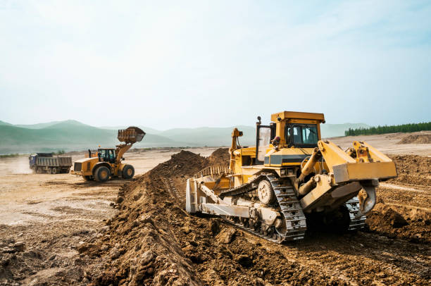 lavoro di terra, macchinari funzionanti in una giornata estiva - caterpillar truck foto e immagini stock