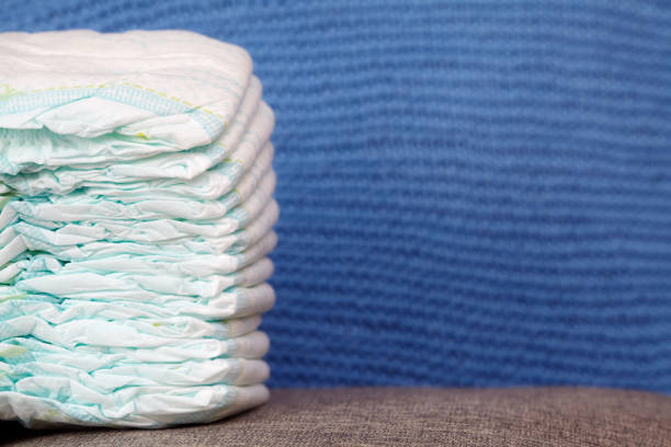 istock Stack of diapers or nappies on blue knitted background 666332512