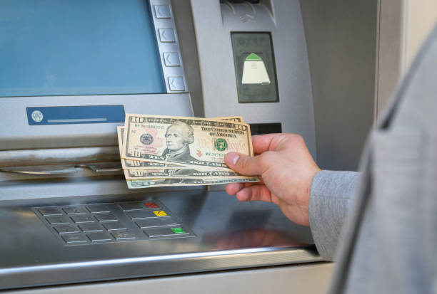 istock man hand show dollar bills in front of atm 666346380