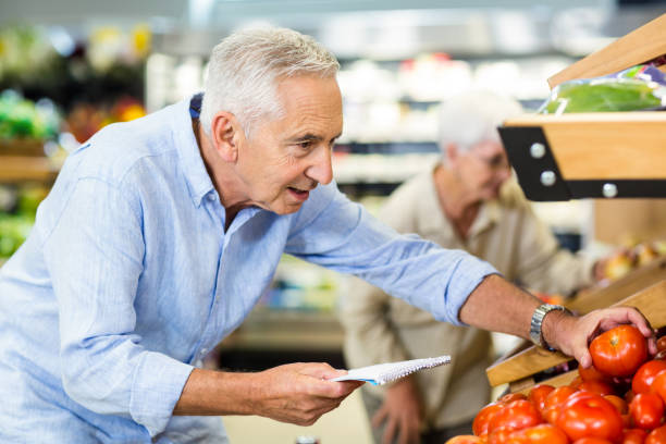 istock Smiling senior man with list buying apple 666356262