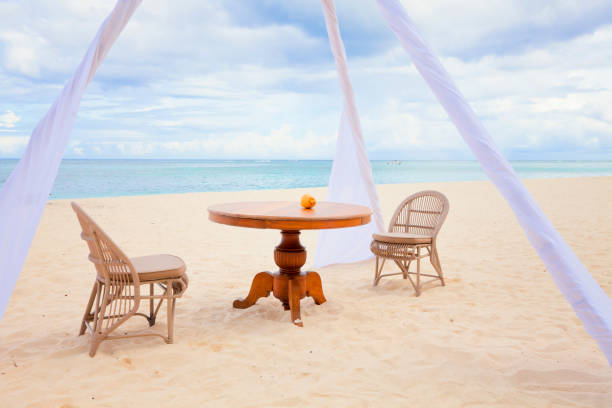 istock Private dining table and wicker chairs for romantic dinner for honeymoon couples on a tropical beach 666361480