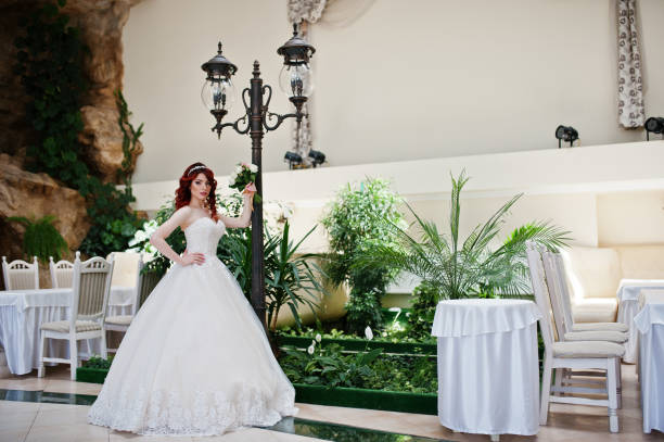 noiva red-haired charming com o ramalhete do casamento na mão posed no grande salão do casamento - loose hair - fotografias e filmes do acervo