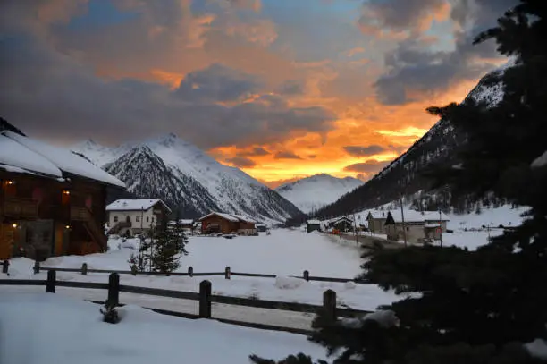 tramonto invernale su paesaggio innevato e montagne -  winter sunset with mountains and snow