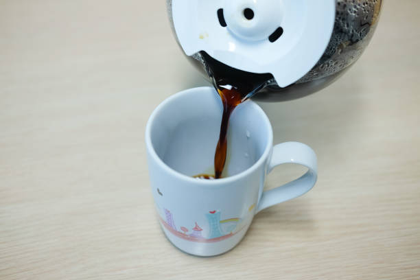 istock Close up of hand holding coffee maker while pouring coffee on cup 666364572