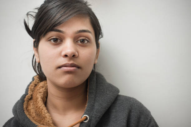 Close-up of serene Asian girl thinking. Indoor image of a serene Asian girl thinking with blank expression and looking at camera. One person, head and shoulders, horizontal composition with copy space. critical thinking kids stock pictures, royalty-free photos & images