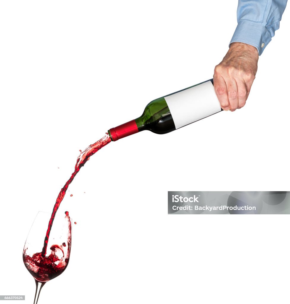 Wine pouring from bottle into glass Red wine being poured directly from wine bottle with a blank label into a large goblet Pouring Stock Photo