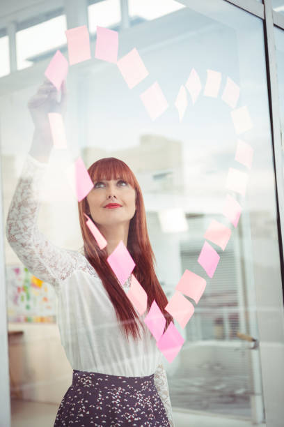 istock Smiling hipster woman doing a heart in post-it 666371390